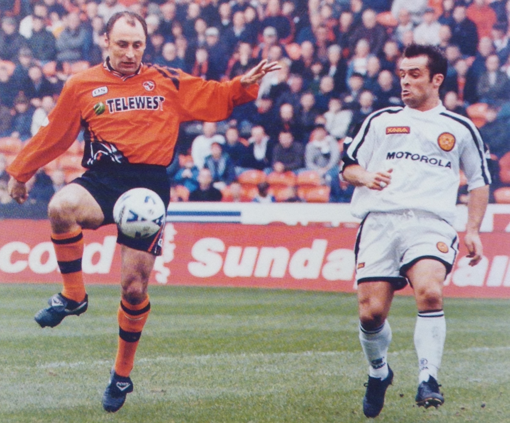 Dundee United's veteran defender Malpas clears the danger as John Spencer looks on.