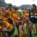 Dougie Arnott holds the trophy as the side clearly enjoy the cup win